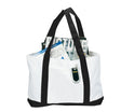 White tote bag with black handles holding magazines on a white background